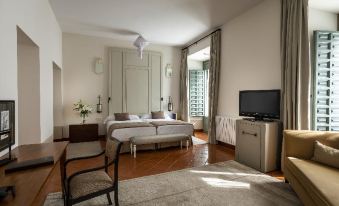 a modern bedroom with white walls , wooden floors , and a large window , featuring a comfortable bed , tv , and desk at Parador de La Granja
