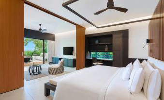 a modern bedroom with a large bed , a television , and a view of the ocean at The Westin Maldives Miriandhoo Resort