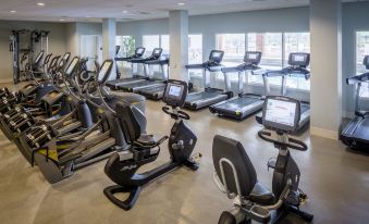 a large room filled with various exercise equipment , including treadmills , stationary bikes , and other cardio machines at Nationwide Hotel and Conference Center