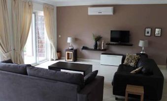 a living room with a couch , chairs , and a flat screen tv mounted on the wall at The Lansdown