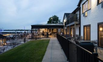 a building with a patio and outdoor seating area is surrounded by greenery and has people sitting in the background at Lakeside Inn