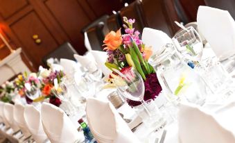 a long dining table set for a formal event , with multiple place settings and flowers at County Hotel