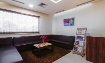 a well - lit waiting room with a couch , table , and various items on the walls , giving it an inviting atmosphere at Hotel Bella Vista