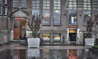 a rainy day in amsterdam , netherlands , with a group of people standing outside a building at Hotel New York