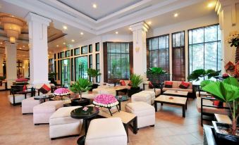 a large , well - lit hotel lobby with multiple couches and chairs arranged for guests to relax at Tara Angkor Hotel
