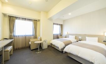 a hotel room with two beds , one on the left and one on the right side of the room at Dormy Inn Mishima