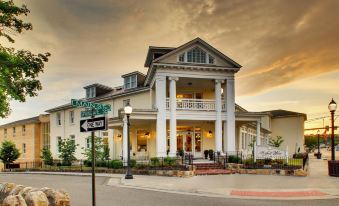 a white building with columns and a balcony is situated on the corner of a street at The Inn at Wise