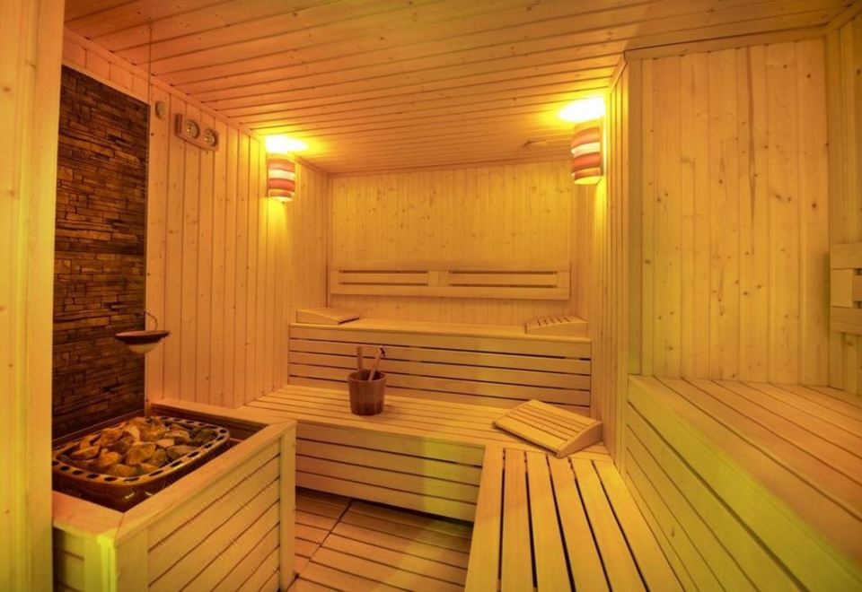 a modern wooden sauna with multiple benches and lighting , providing a warm and inviting atmosphere at Ana Hotels Europa Eforie Nord