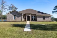 Enjoy this waterfront home with a pool, dock, and Blue Angels! Bring your boat!