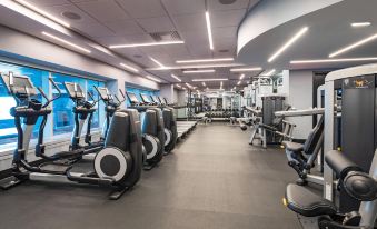 a large , well - equipped gym with multiple exercise equipment , such as treadmills , stationary bikes , and weight machines at W Hoboken