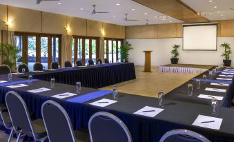 a conference room with rows of chairs arranged in a semicircle , and a projector screen on the wall at Novotel Suva Lami Bay