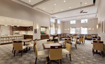 a large , well - lit dining room with multiple tables and chairs arranged for a group of people at Homewood Suites by Hilton Frederick