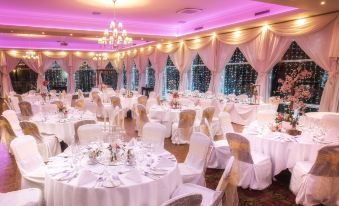 a well - decorated banquet hall with white tables and chairs set up for a formal event at The Inn at Dromoland