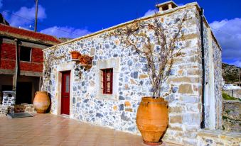 a stone house with two large flower pots in front of it , creating a welcoming atmosphere at Villa Rosa