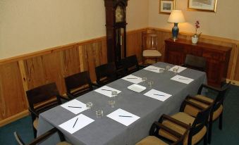 a conference room set up for a meeting , with a long table and chairs arranged in a semicircle at Castletown Hotel