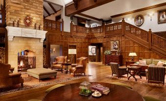 a spacious living room with wooden paneling on the walls , a fireplace , and multiple couches and chairs at The Sewanee Inn