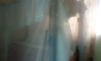 a white canopy over a bed in a room , casting light on the outside of the room at The Reeds Hotel