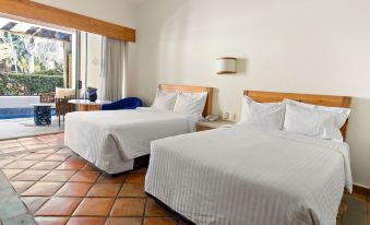 a hotel room with two beds , one on the left and one on the right side of the room at Hotel Rancho San Diego Grand Spa Resort