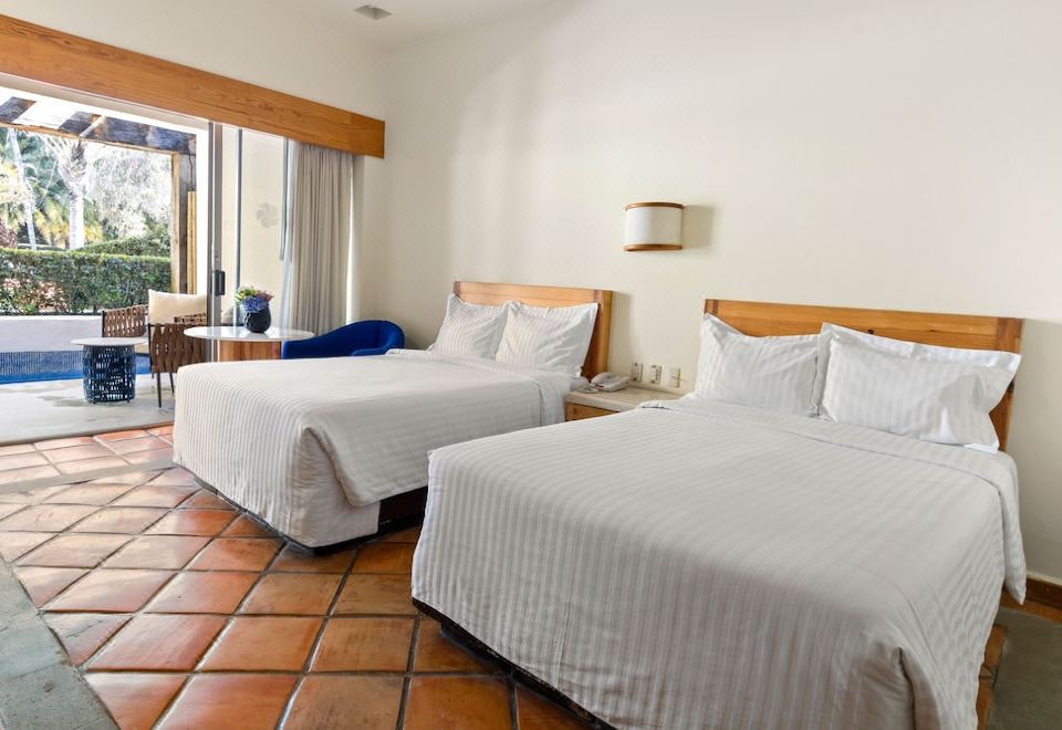 a hotel room with two beds , one on the left and one on the right side of the room at Hotel Rancho San Diego Grand Spa Resort