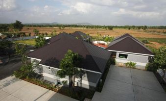 a group of houses with brown roofs and a view of the countryside in the background at Rongsang Resort