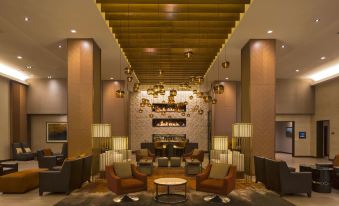 a modern hotel lobby with high ceilings , wooden beams , and multiple couches arranged around a coffee table at Grand Hyatt Denver