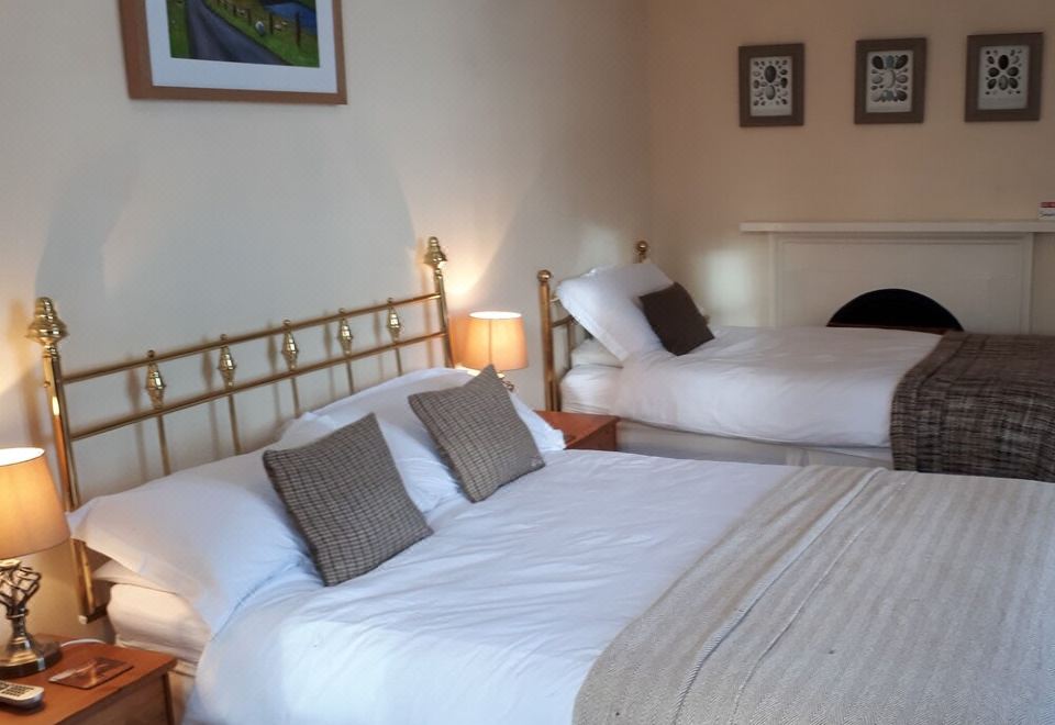 a room with two beds , one on the left and one on the right side of the room at Rigg House B&B