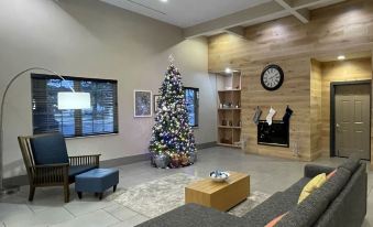 a modern living room with a large window , wooden walls , and a christmas tree in the center at Country Inn & Suites by Radisson, Kalamazoo, MI