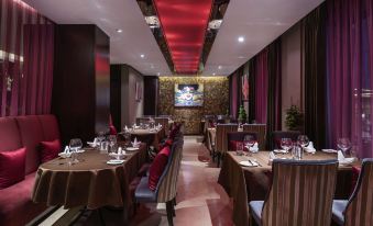 The restaurant features tables and chairs arranged in a central area, facing each other at Novotel Beijing Peace