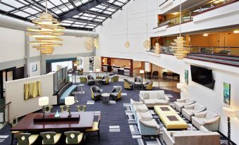 a large hotel lobby with various seating options , including couches and chairs , as well as potted plants at DoubleTree by Hilton Richmond - Midlothian