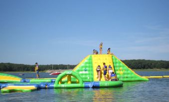 a group of children playing on an inflatable obstacle course in a body of water at Honey Creek Resort