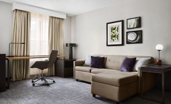 a living room with a beige couch , a chair , and a painting on the wall at Residence Inn Harrisburg Carlisle