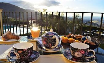 a table with a teapot , cups , and saucers is set up on a balcony overlooking the city at La Castellana