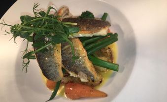 a plate of food on a dining table , with a variety of vegetables and fish at The Mendip Inn