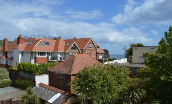 a row of houses with red roofs and a clear blue sky in the background at The Rookery