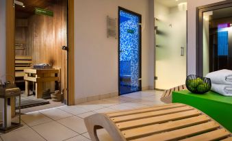 a modern living room with wooden furniture , including a green bench and a blue window at Park Inn by Radisson Katowice