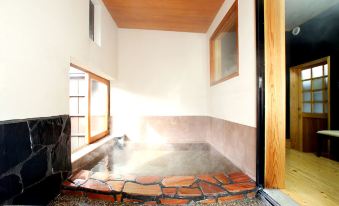 The main room is a spacious spa with an indoor jacuzzi and air conditioning at Minshuku Asogen