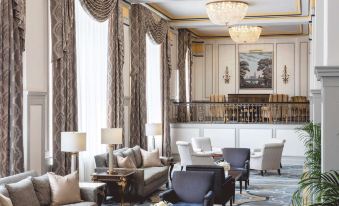 a luxurious hotel lobby with marble floors , large windows , and comfortable seating areas under chandeliers at Francis Marion Hotel