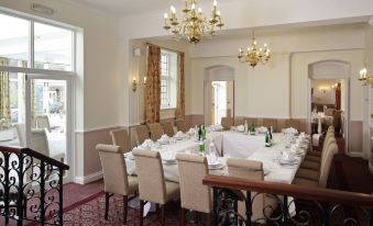 a large dining room with a long table covered in white tablecloths , surrounded by chairs at Letchworth Hall