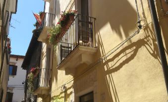 a narrow street with yellow buildings , balconies , and plants , providing a picturesque view of the town at Legacy