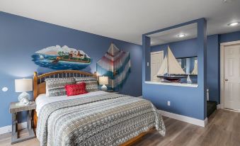 a bedroom with blue walls , wooden floor , and a bed decorated with a ship and sailboat mural at The Bradford