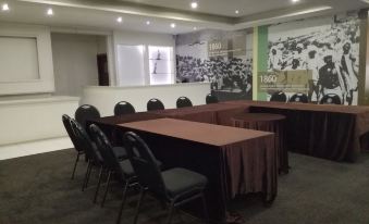 a conference room with multiple tables and chairs , a large window , and a large mural on the wall at Hotel Savera