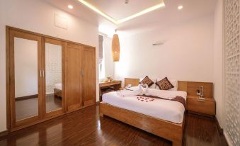 a large bed with a wooden headboard is in the middle of a room with hardwood floors at Sepon Boutique Resort