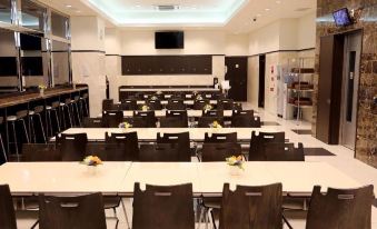 a large conference room with multiple tables and chairs arranged for a meeting or event at Toyoko Inn Meitetsu Chiryu Ekimae