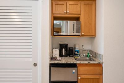 a small kitchen with wooden cabinets , a microwave , a coffee maker , and a sink on the counter at Wyndham Reef Resort Grand Cayman