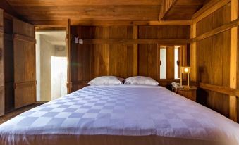 a wooden bedroom with two beds , one on top of the other , and a television mounted on the wall at Berugo Cottage