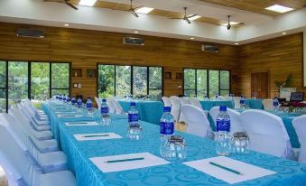 a long table with blue tablecloth and water bottles is set up in a conference room at Dream Valley Belize