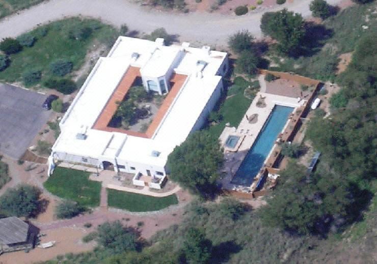 an aerial view of a large white house surrounded by trees , with a pool in the foreground at Casa de San Pedro Bed & Breakfast