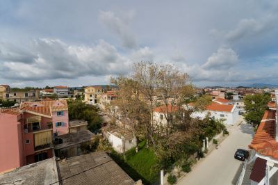 a view from a high vantage point of a residential area with trees , houses , and clouds in the background at Hotel Summery