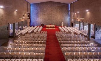 a large room with rows of white chairs and a red carpet , possibly for an event or a wedding at Lantana Garden