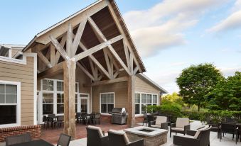 a patio area with several chairs and a grill , surrounded by trees and a building at Residence Inn Philadelphia Langhorne
